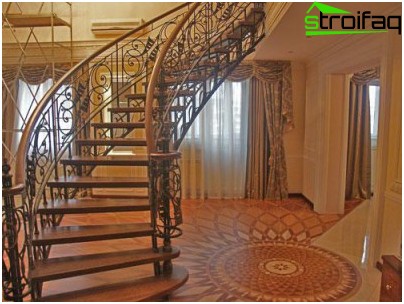 透かし彫りの錬鉄製の囲いで縁取られたダークウッドの階段は、インテリアに特別な荘厳さを与えます