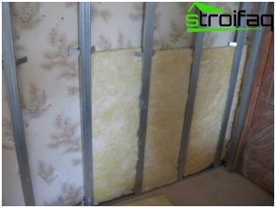 壁と乾式壁の間の空間を満たすミネラルウール 追加の断熱と遮音のために、ボイドはミネラルウールで満たされています